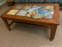 Full view of wood framed coffee table with natural stone tile inserts and decorative mirror placed on top