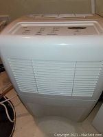 Front view of white Whirlpool Gold dehumidifier showing air vent grille and power cord.