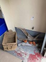 Photo showing large driftwood piece next to a braided basket on the floor