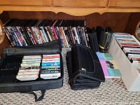 Image showing DVDs, CDs, and cassettes organized on the floor and in cases, various titles visible on DVD spines
