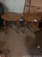 Top view of two round wooden end tables showing wood grain finish and curved legs.