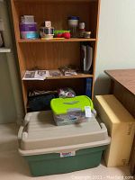 Wooden shelving with multiple plastic containers of sewing supplies and tools on and in front of shelves.