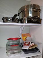 Top shelf view showing stacked Paderno metal roasting pans with lids and Milano fry pan with inserts.