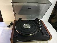 Sansui SR-313 belt drive turntable with dust cover open, showing platter, tonearm and control switches, wood side panels.