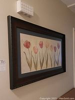 Framed floral print with tulips in soft colors hanging on wall, showing full image and frame dimensions
