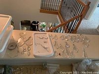 Overview of all assorted chandelier crystals laid out on ledge, showing variety of crystal shapes and cuts.