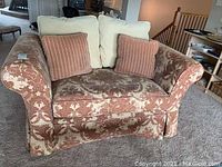 Full view of the loveseat showing its pattern, cushions, and shape.
