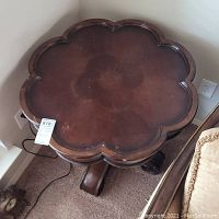 Top view showing flower-shaped wooden tabletop with scratches and finish wear.