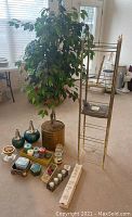 Full view showing the faux tree, display stand, vases, candles, and small containers grouped on the floor.