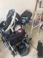 Lumex wheelchair-style walker alongside adjustable lightweight walker with tennis balls on rear legs, bags and accessories visible