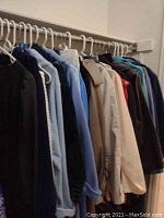 Rack of women's coats, jackets, and bathrobes in various colors hung on hangers.