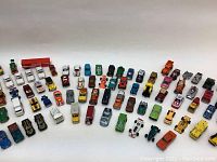 Full view of 91 vintage assorted die-cast toy cars arranged in rows, displaying variety in model types and colors