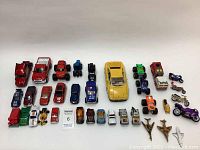 Overview of 35 assorted vintage die cast cars, motorcycles, airplanes, and trucks in various sizes and colors, arranged on a plain white surface, showing condition and variety.