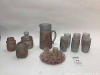 Photo showing full set of 16 hand painted glass items including pitcher, glasses, jars, liqueur glasses, and plate.