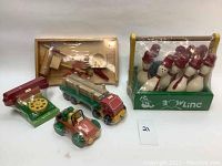 Collection of five sealed vintage wooden toys including bowling set, toy truck, toy car, toy stove, and kitchen utensils set.
