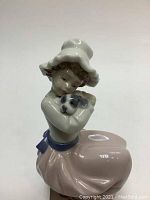 Front left side view showing girl's face, hat, and dog in arms