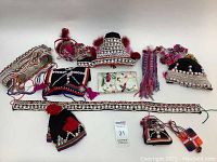 Full overview of 12 handmade souvenir clothing and accessory pieces representing traditional Thai and Lao textiles and craftsmanship