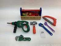 Complete set of wooden and plastic toy tools with tool holder on white background.