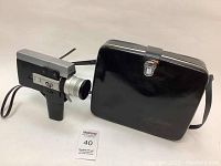 Vintage Canon Super 8mm video camera next to its black carrying case, showing full front and side profile of both items