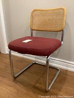 Angled front-left view showing chrome frame, red seat, cane back