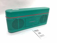 Front perspective view of the green and red Sharp stereo showing grille speaker fronts, cassette deck, and branding.