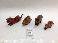 Four wooden 3D animal puzzles including a dragon, armadillo, bear, and turtle, displayed together on a white surface.