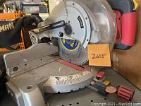 10 inch Craftsman chop saw showing saw blade, adjustable angle gauge, red and black handle, and dust bag attached.