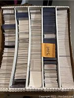 Box of sports cards organized in several sections with dividers, showing a dense collection of cards.