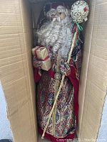 Large Santa Claus figurine inside cardboard box