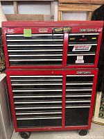 Front view of red two-piece Craftsman tool chest and cabinet with drawers and stickers