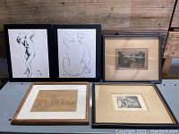 Wide view of all five framed lithographs arranged on the floor, showing variety of art styles and frame types