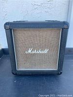 Front view of the Marshall speaker showing 10 inch woofer behind beige grill and Marshall logo.