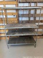Front view of the metal industrial shelving unit showing four shelves and overall rectangular frame.