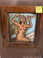 Front view of the wood carving artwork showing nude female figure and rainbow background with wooden frame and 'The Seeker' label.