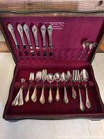 Full set of 53 pieces of silver plated flatware in original fitted case with burgundy velvet lining and 1847 Rogers Bros branding on inside lid.