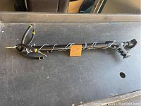 Full view of the spearfishing rig showing handle, shaft, and three rubber bands fixed at the tip.