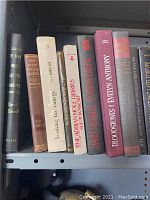 Close-up photo of vintage hardback books on shelf showing a variety of titles and bindings