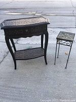 Wicker style table and metal plant stand placed outdoors on concrete surface, showing overall shape and dimensions.