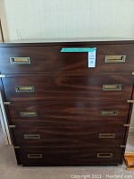 Front view of mahogany tall dresser showing five drawers and brass recessed pulls