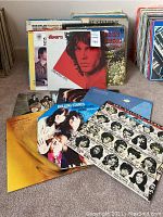 Front view of stacked records featuring The Doors Greatest Hits and The Rolling Stones Singles Collection