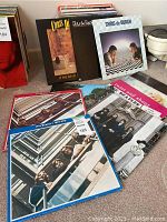 Two Chris de Burgh LPs and multiple Beatles compilations laid on the floor