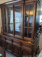 Front angled view of the Gibbard china cabinet and sideboard showing solid mahogany finish, multiple drawers and cabinet doors, glass panels on the upper cabinet, brass hardware and classic design.