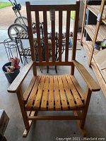 Front view of wooden slat rocking chair showing vertical back slats and horizontal seat slats.