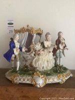 Front view of full porcelain figurine depicting carriage scene with three figures