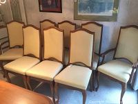 Overview of eight chairs: two with arms at right and six armless at left, all upholstered in striped yellow-beige fabric