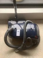 Kenmore Elegance vacuum with hose and cleaning head lying on carpet