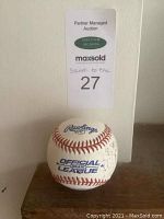 Front view of the Rawlings Official League baseball showing multiple signatures on the surface.