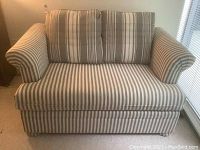 Front view of striped upholstered sofa with rolled arms and two removable back cushions