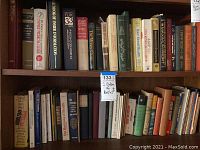 Two full shelves of assorted books showing variety of topics and titles.
