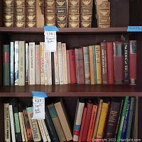 Shelf of various financial and related books including titles on taxes, wills, stocks, and economic history.